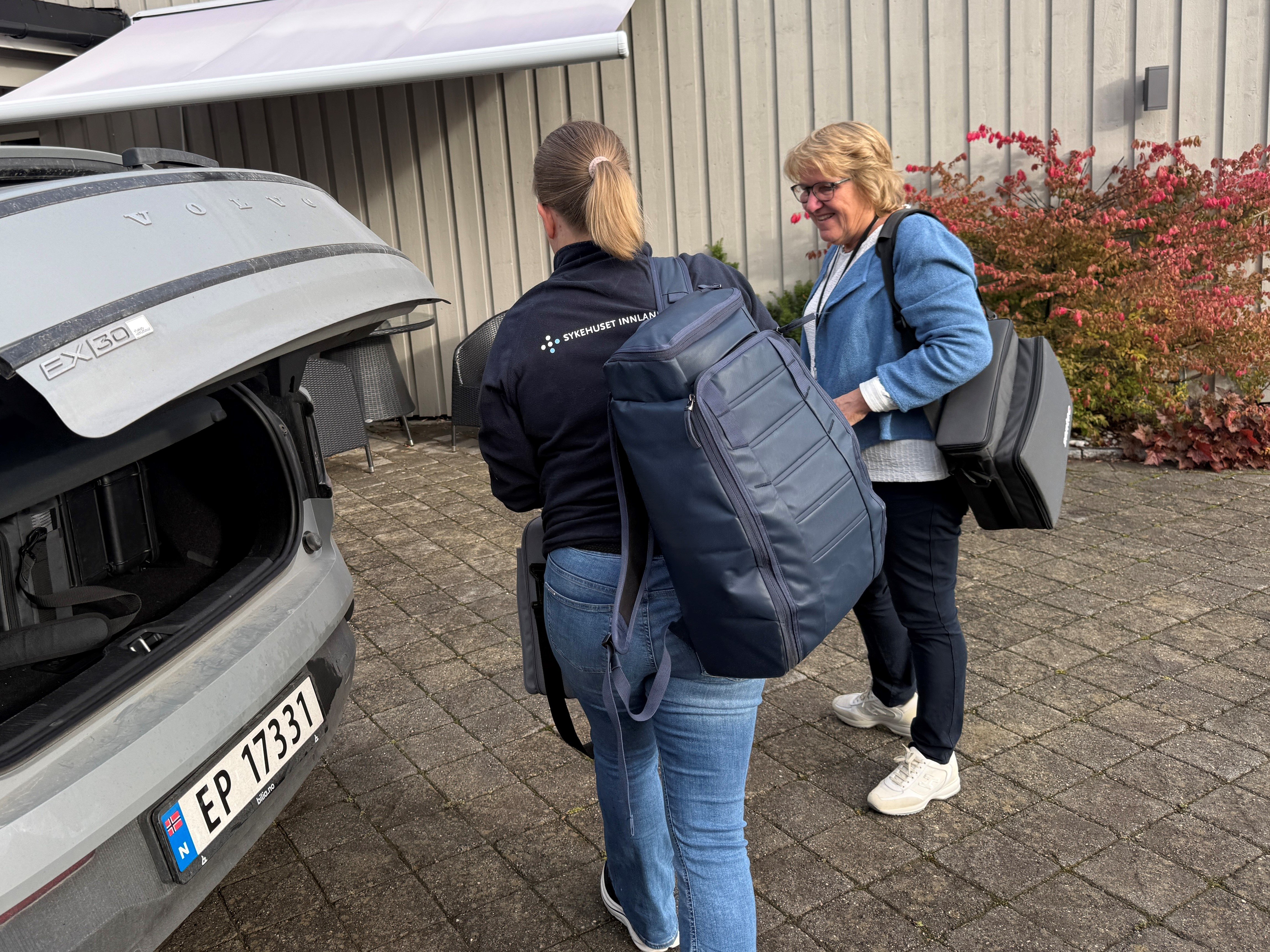 En gruppe mennesker som går forbi en bil