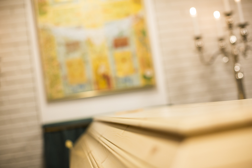 Kiste, tente lys og kors på veggen.