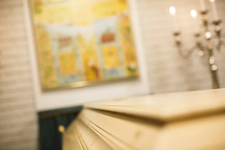 Kiste, tente lys og kors på veggen.