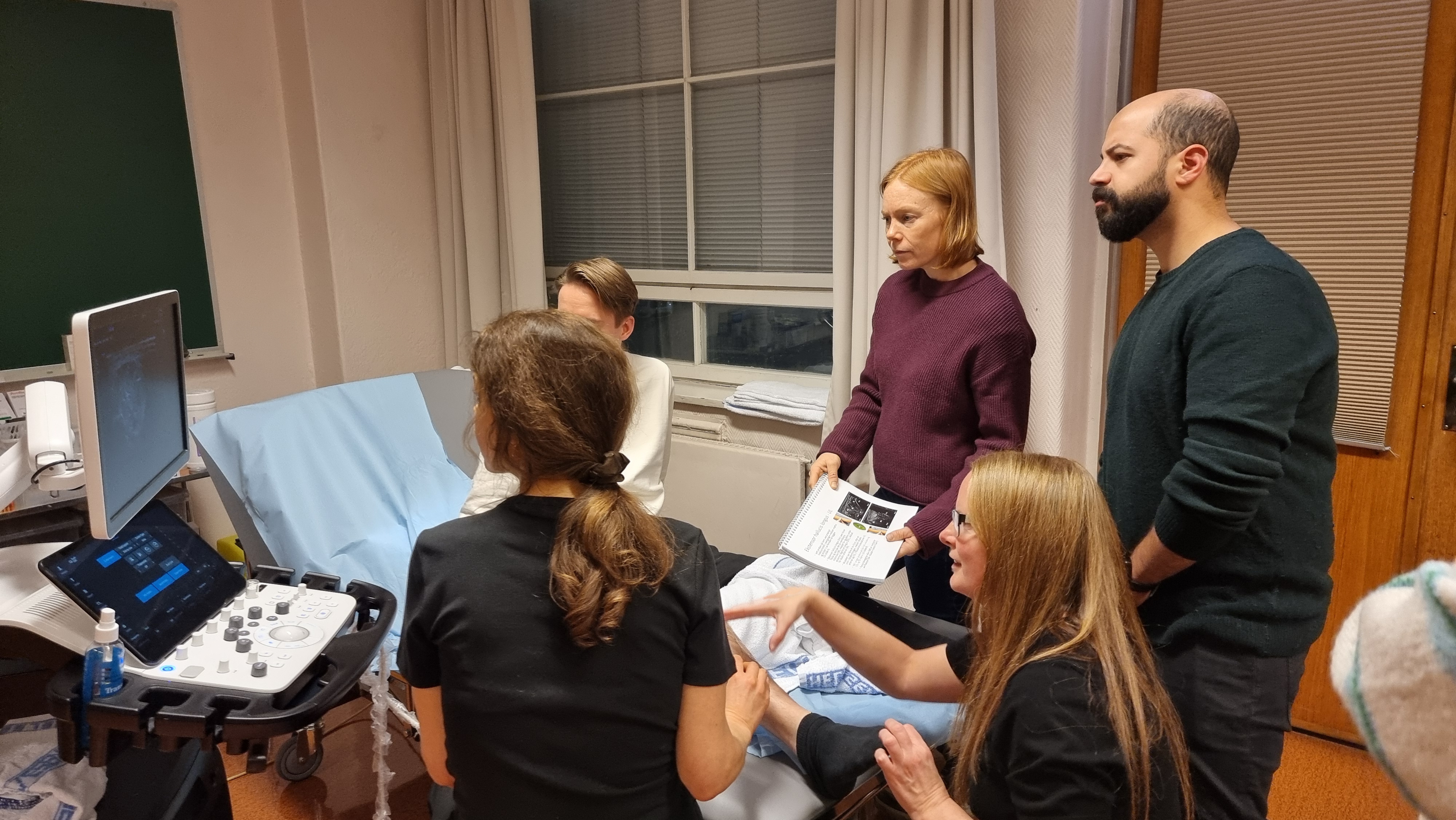 Østlie veileder deltagerne i bruk av ultralyd for å finne det beste injeksjonspunktet i muskelen.