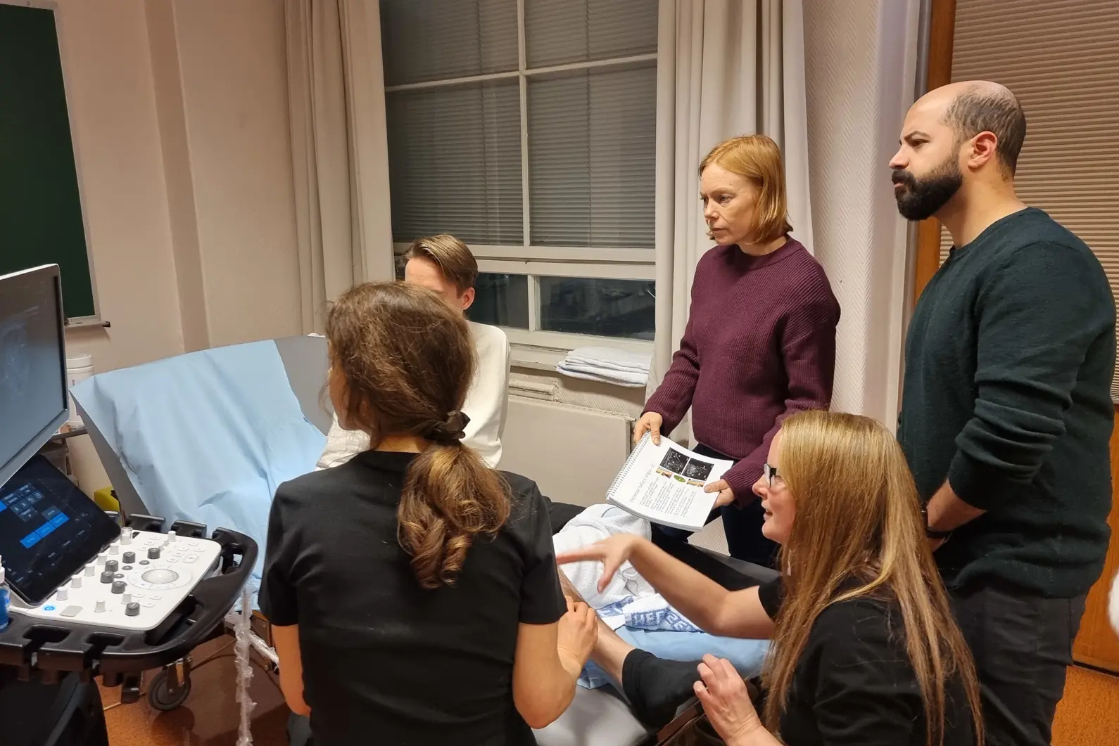 Østlie veileder deltagerne i bruk av ultralyd for å finne det beste injeksjonspunktet i muskelen.