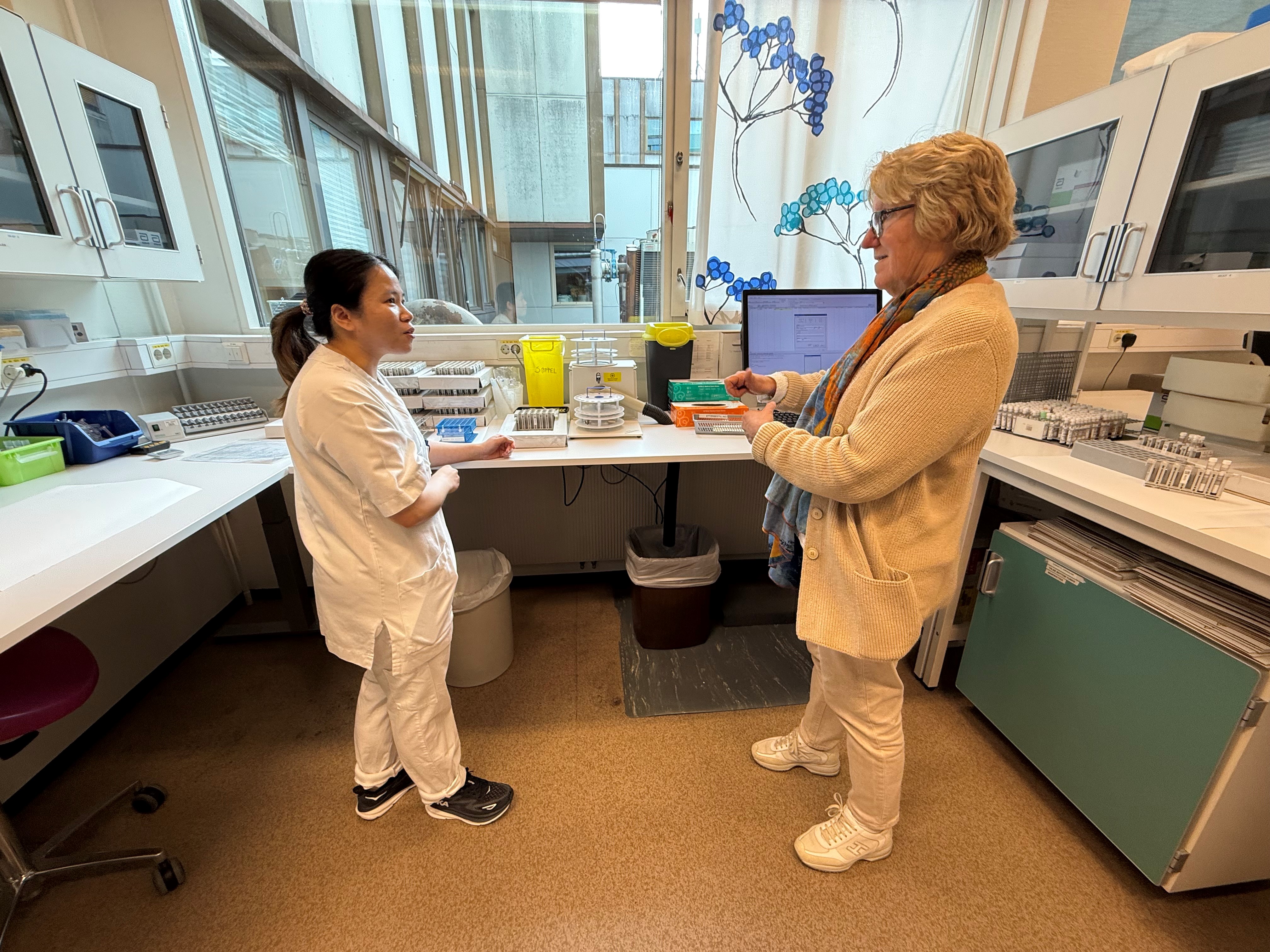 En person som viser en person noe på datamaskinen