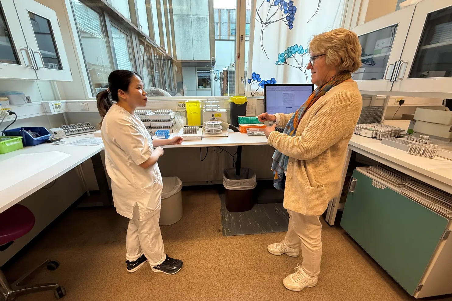 En person som viser en person noe på datamaskinen