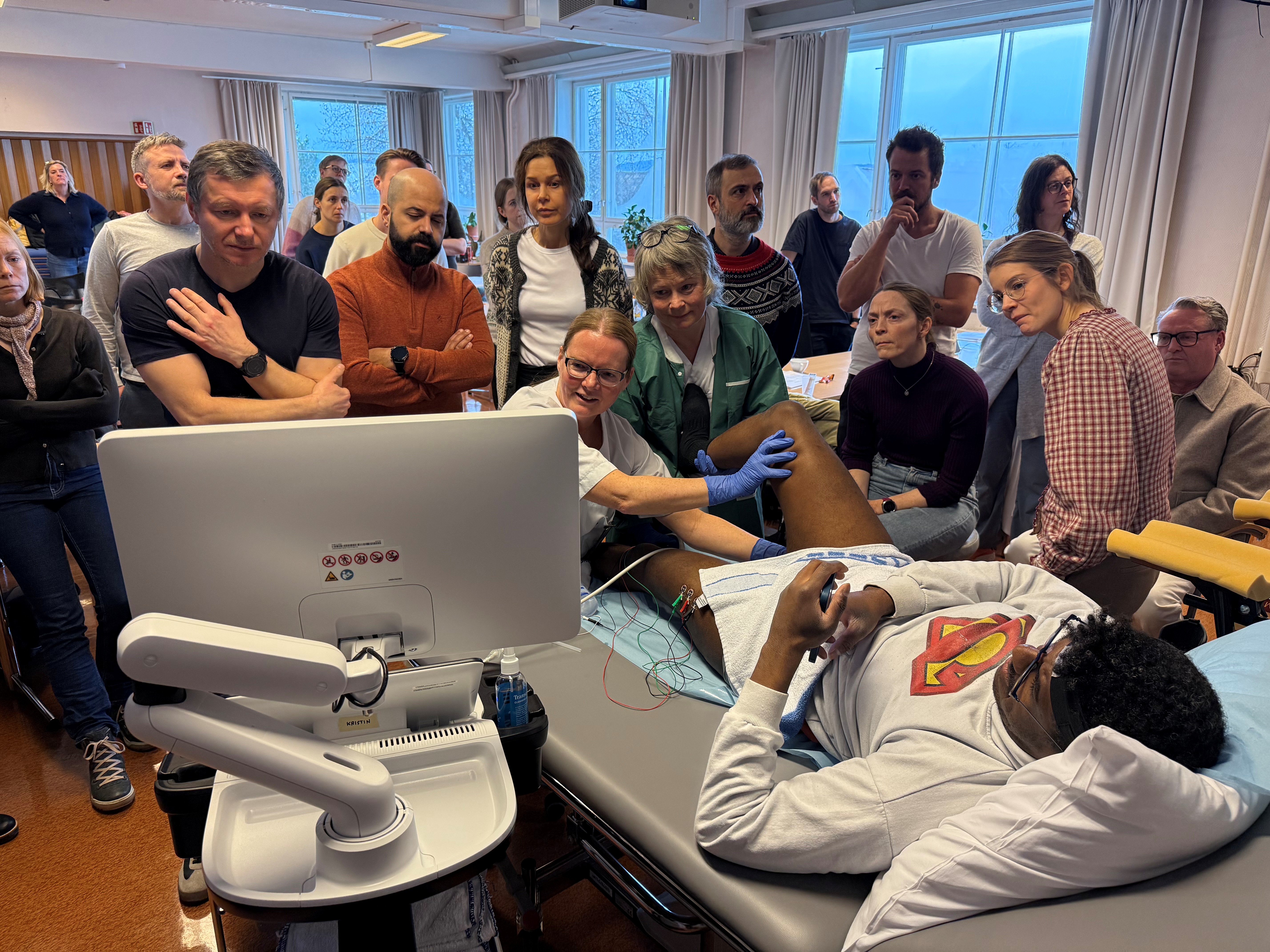 Lege Kristin Østlie demonstrerer injeksjon på pasient foran alle kursdeltakere.