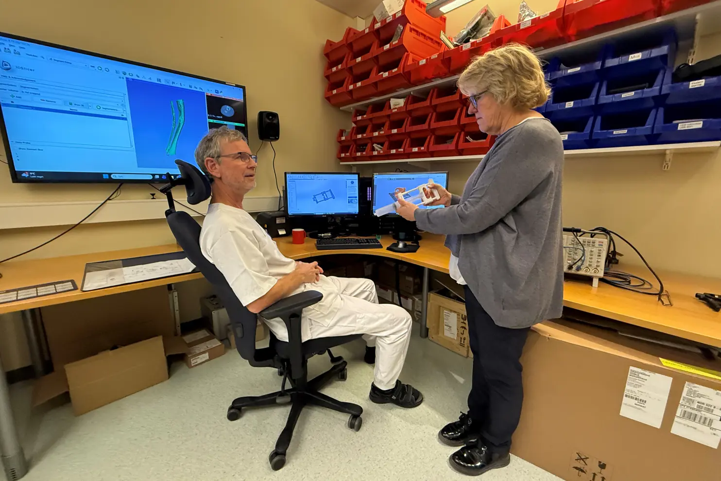 En mann og en kvinne i et rom med en datamaskin