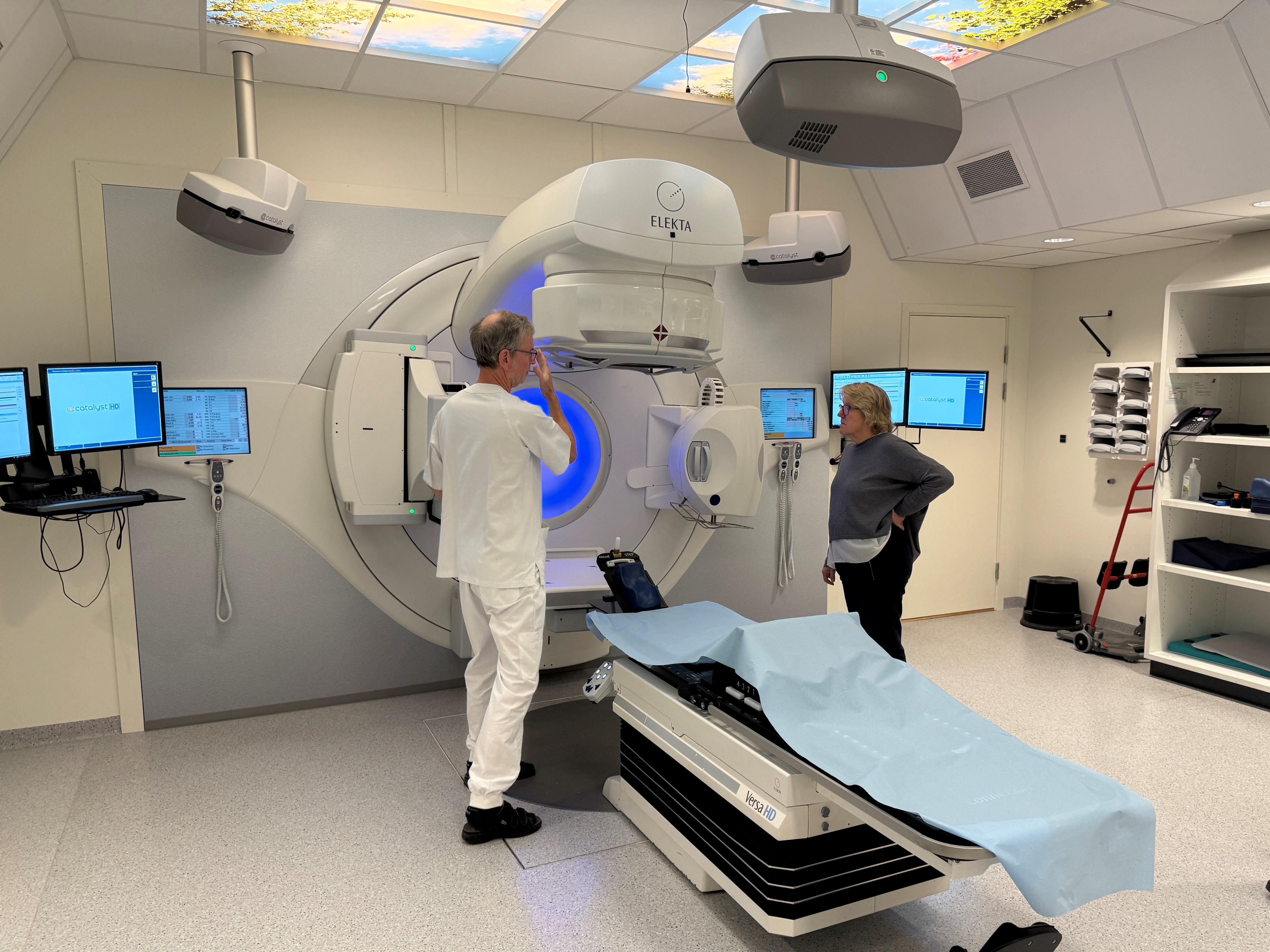 Et par menn på et sykehusrom med medisinsk utstyr