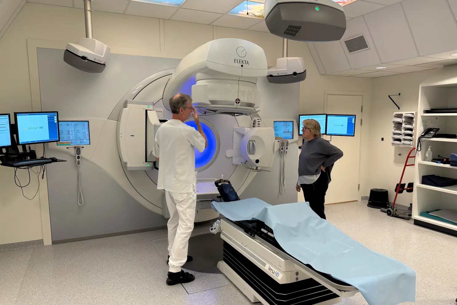 Et par menn på et sykehusrom med medisinsk utstyr