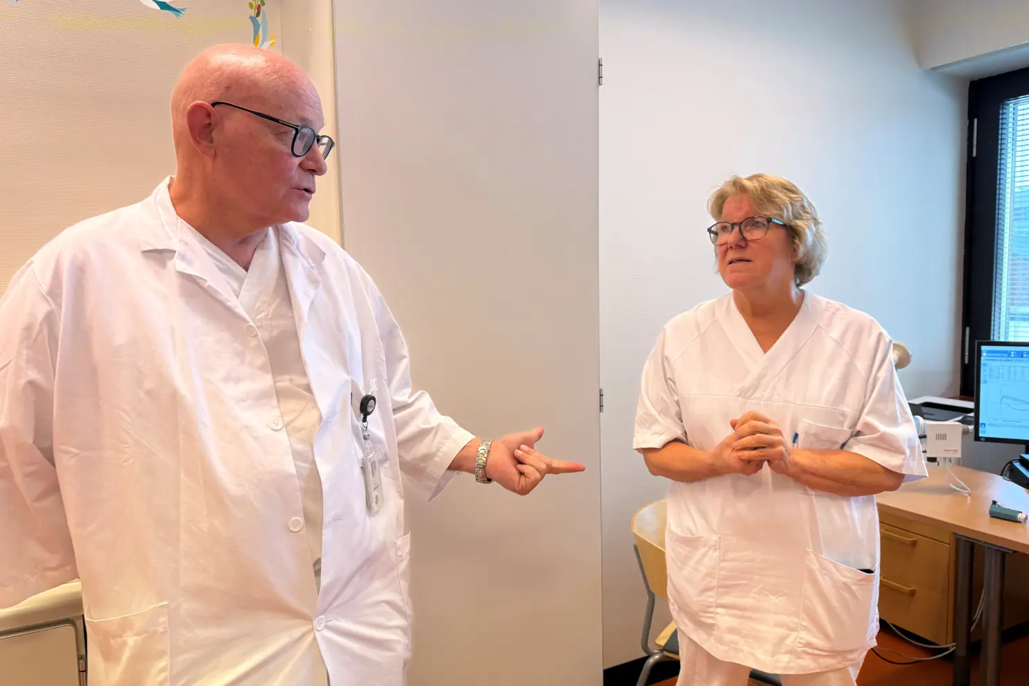 En lege som snakker med en pasient