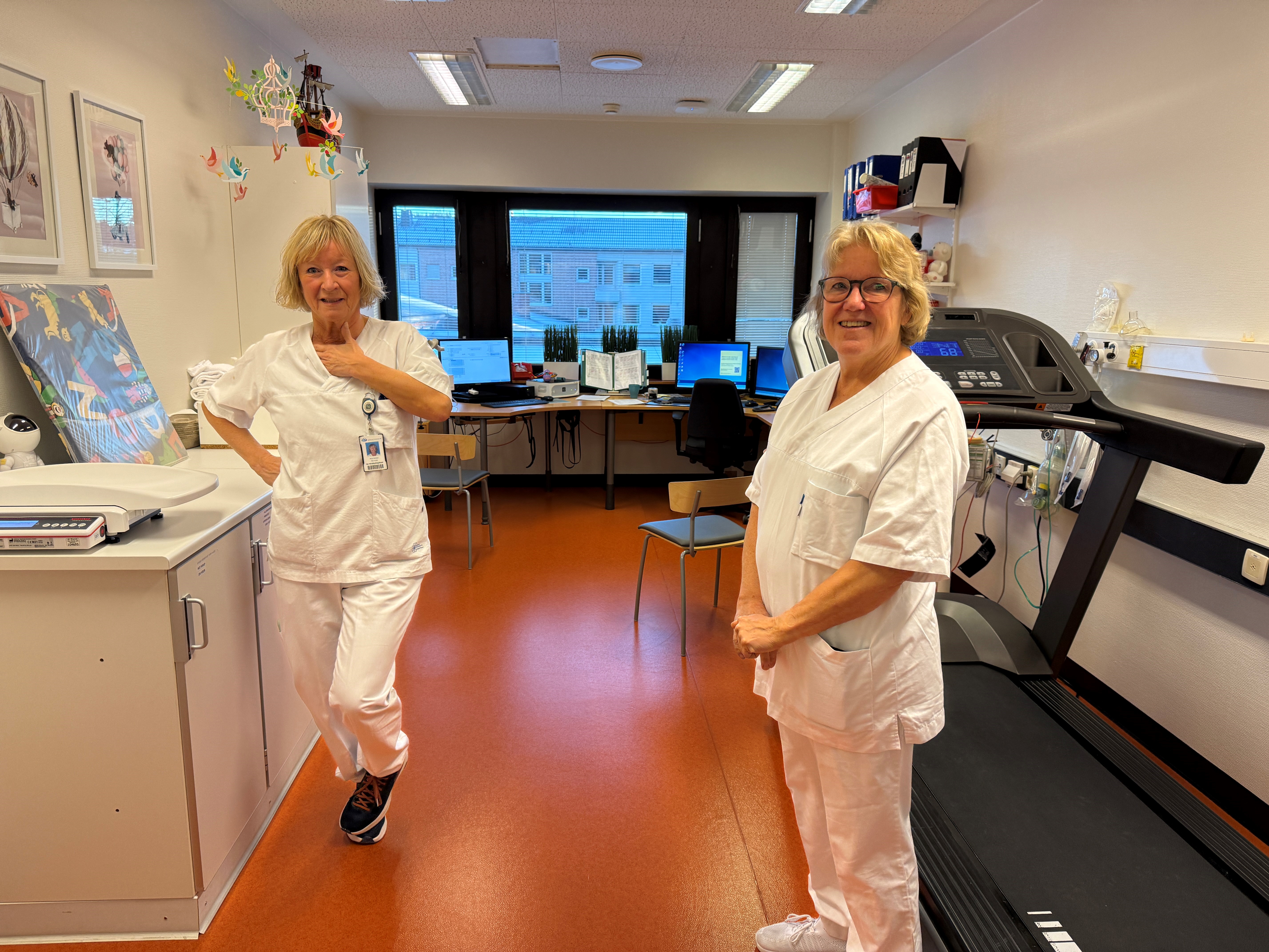 Et par kvinner i hvite laboratoriefrakker i et rom med datamaskiner