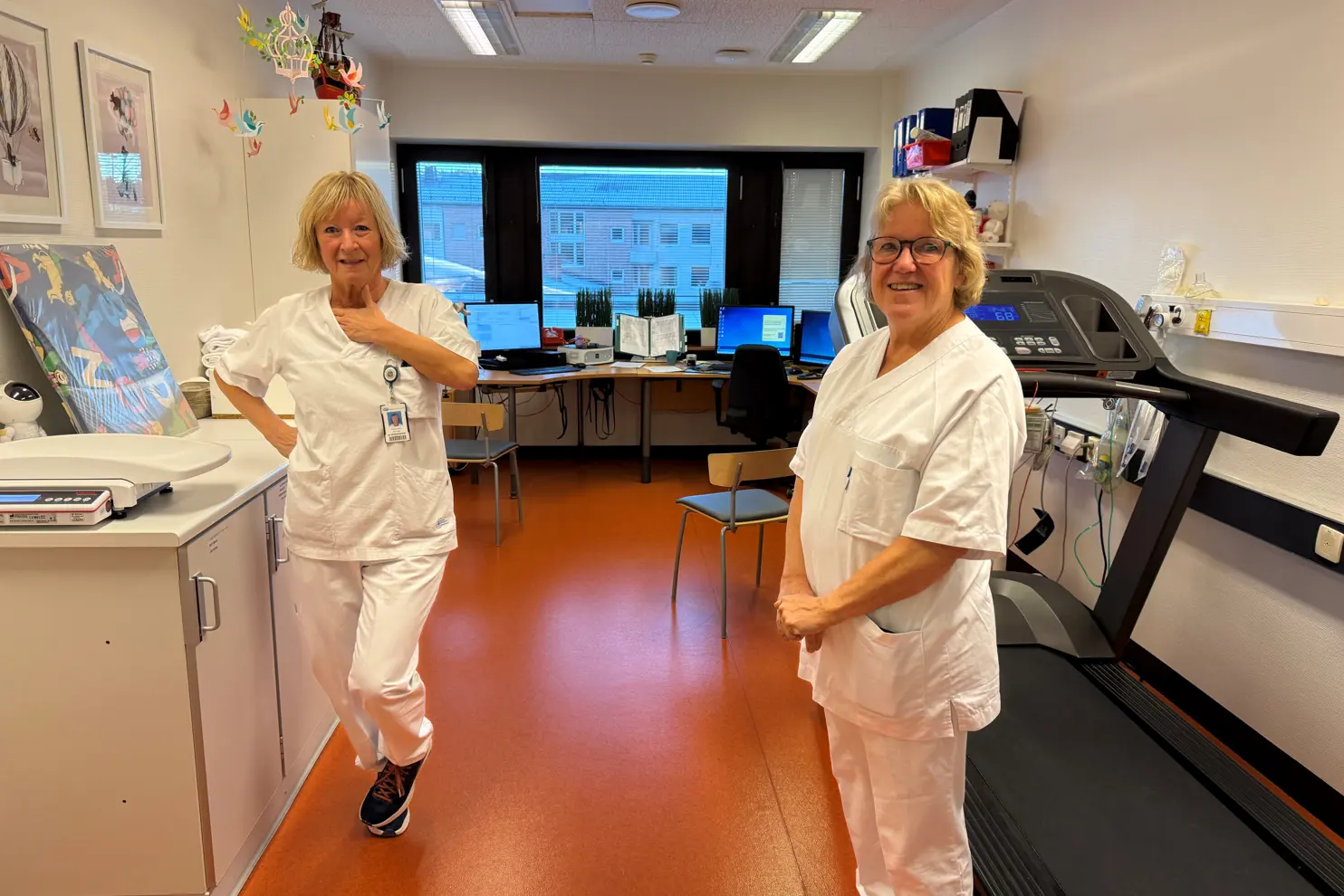 Et par kvinner i hvite laboratoriefrakker i et rom med datamaskiner