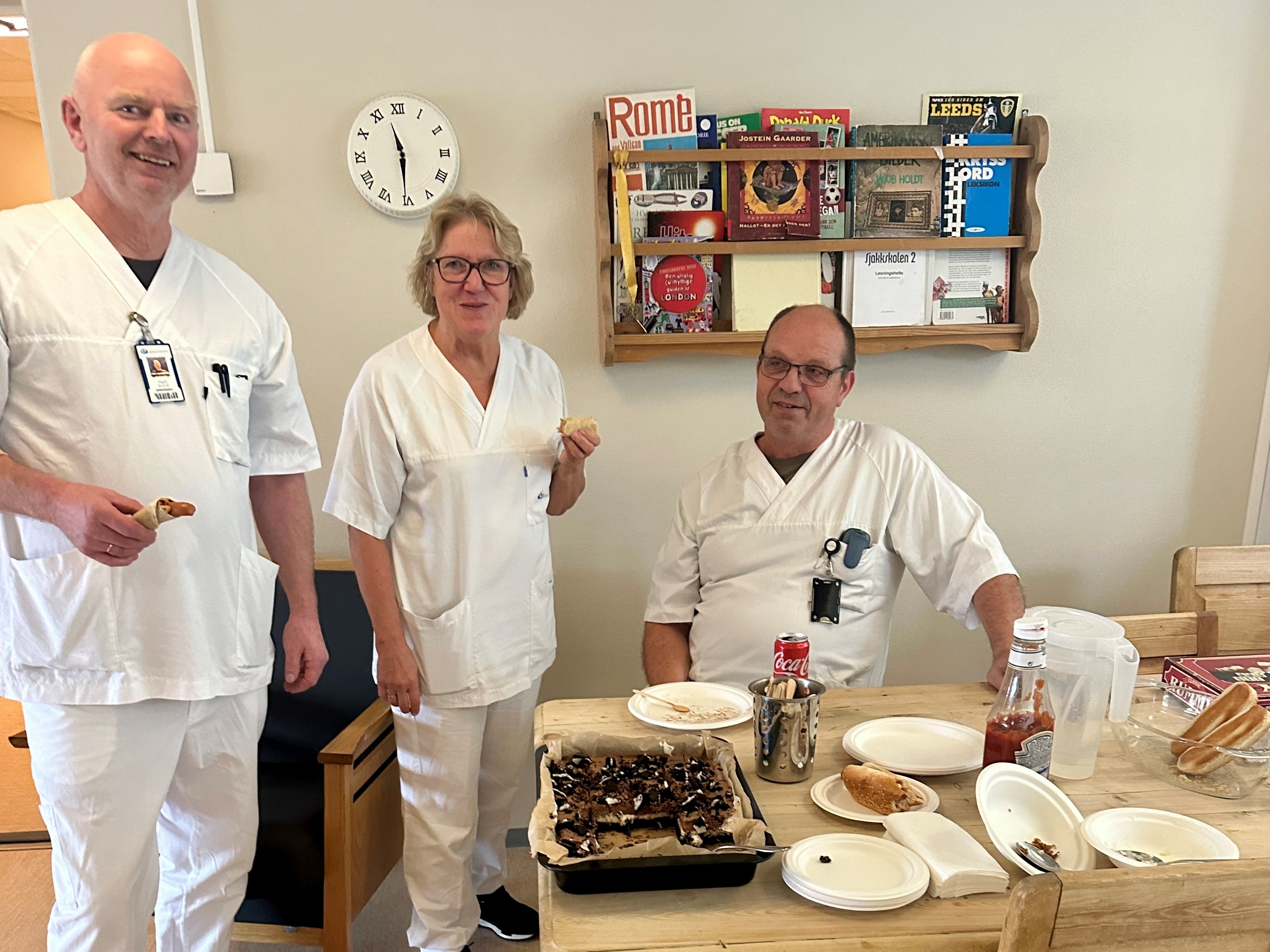 En gruppe mennesker står rundt et bord med mat