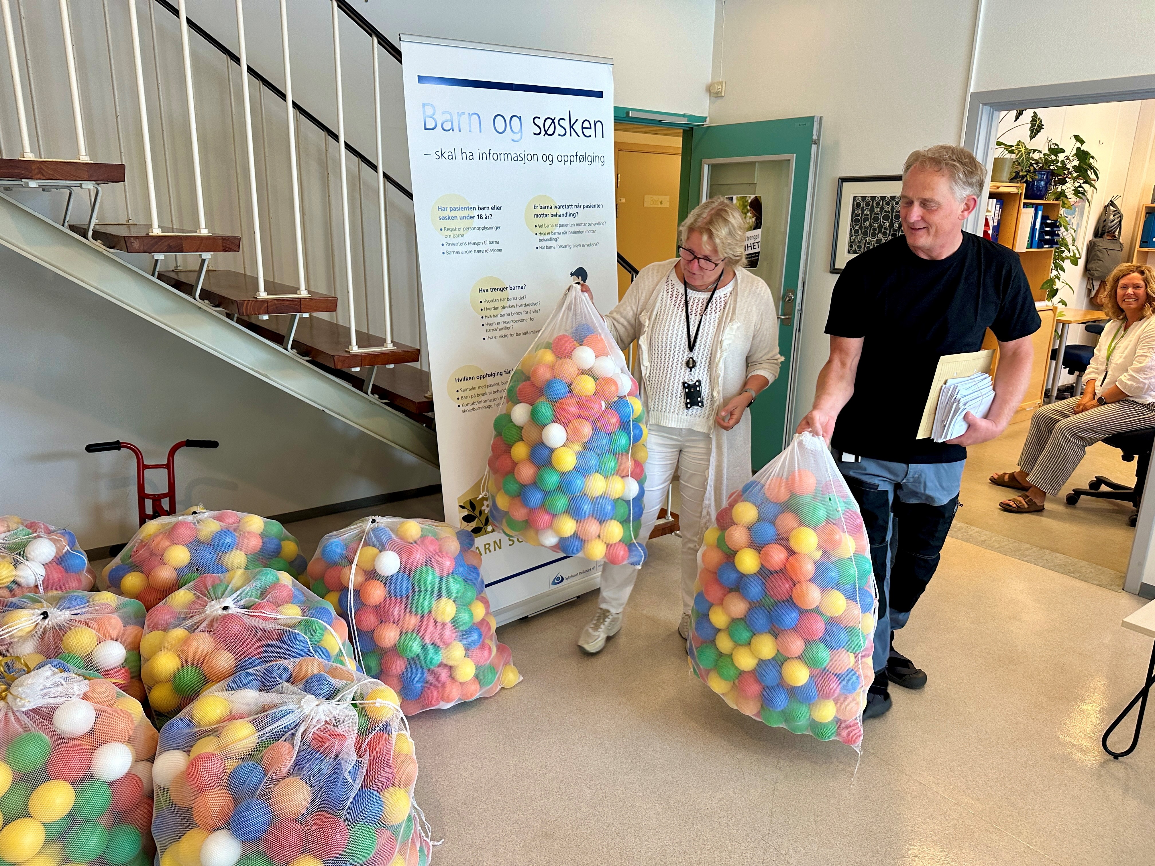 En gruppe mennesker i et rom med mange ballonger