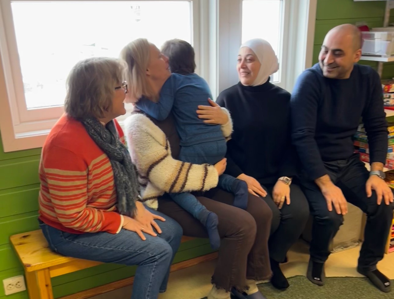 En gruppe mennesker som sitter på en benk