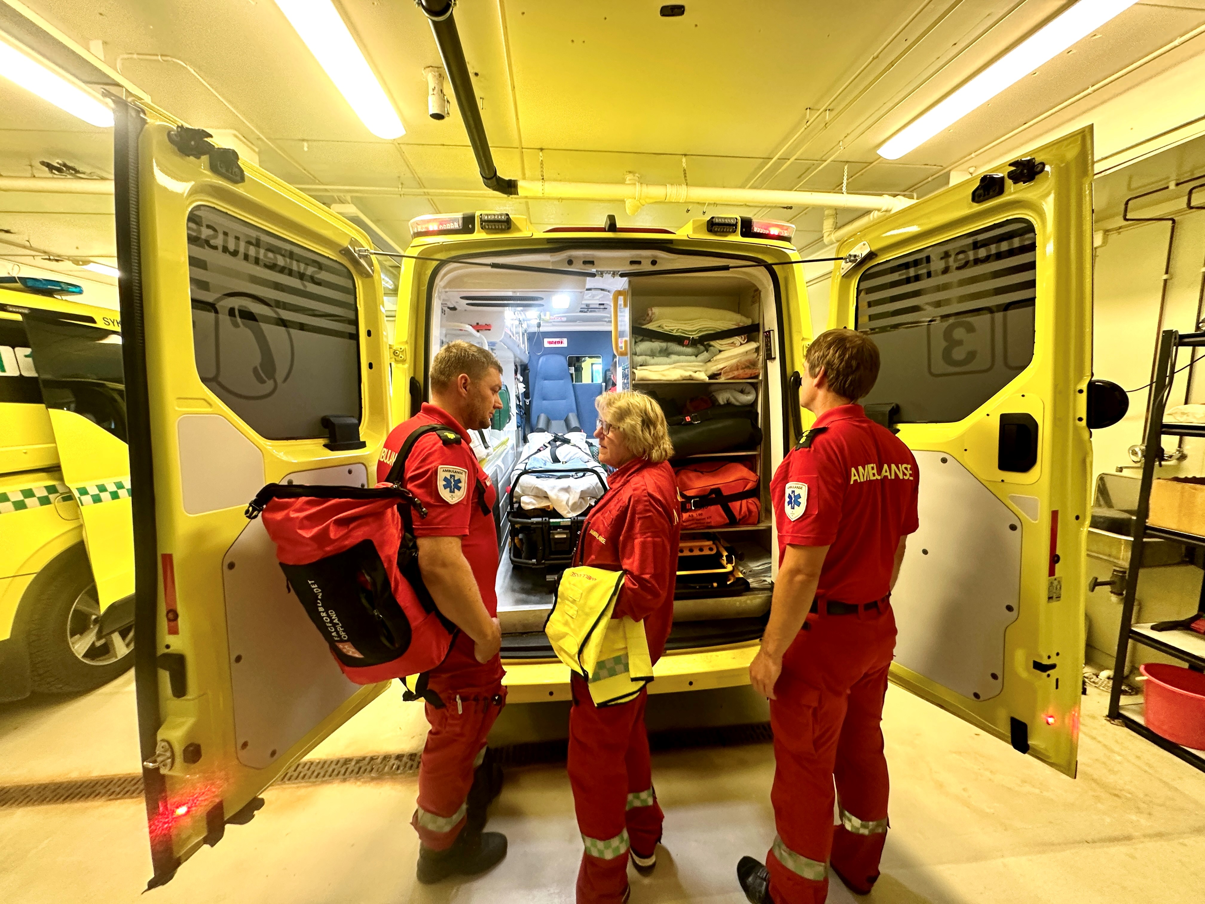 En gruppe mennesker i røde uniformer som står foran en brannbil