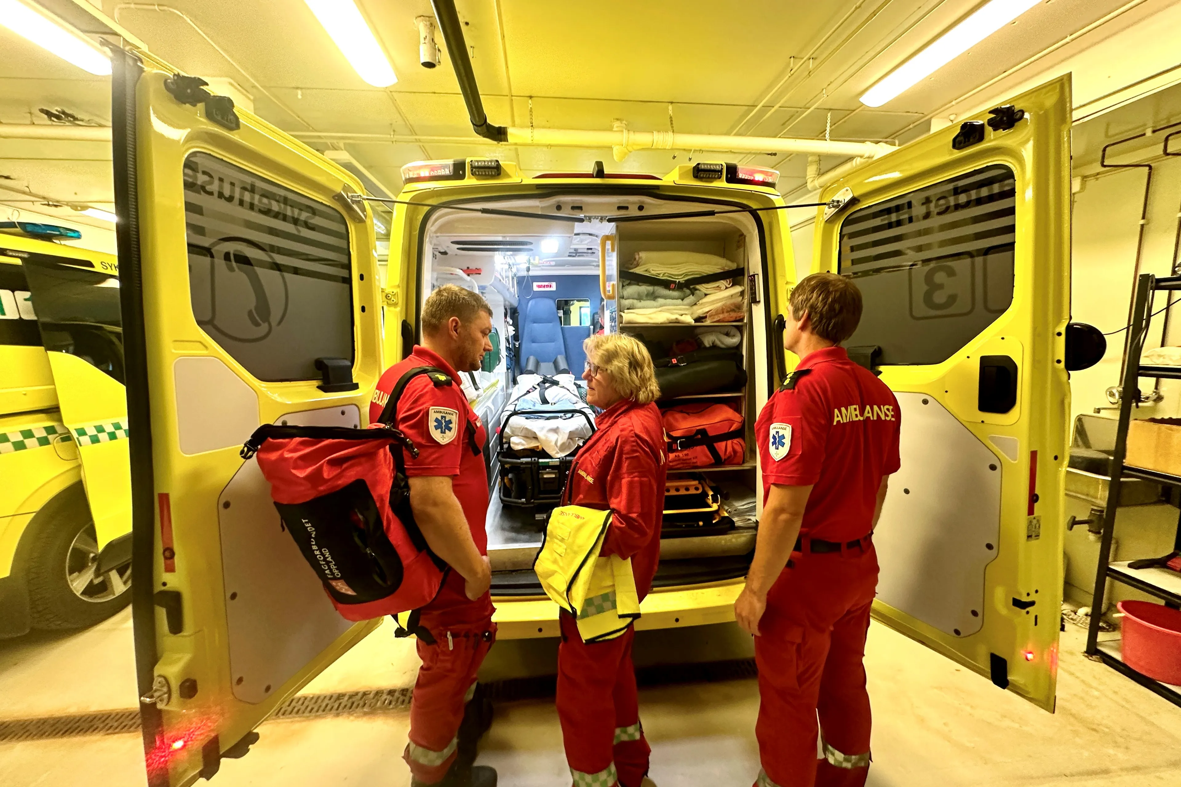 En gruppe mennesker i røde uniformer som står foran en brannbil